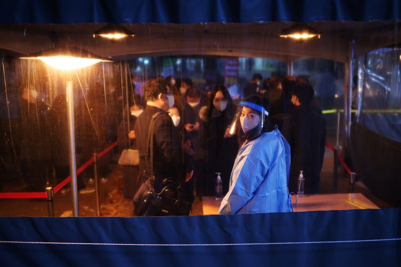 © Reuters. Imagen de archivo de gente esperando en línea para someterse a un examen de COVID-19 en un sitio de pruebas en el centro de Seúl, Corea del Sur. 1 de diciembre, 2021. REUTERS/Kim Hong-Ji/Archivo