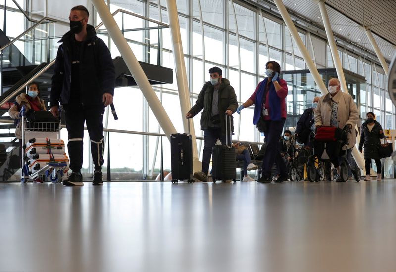 &copy; Reuters. FILE PHOTO: People walk inside Schiphol Airport after Dutch health authorities said that 61 people who arrived in Amsterdam on flights from South Africa tested positive for COVID-19, in Amsterdam, Netherlands, November 27, 2021. REUTERS/Eva Plevier