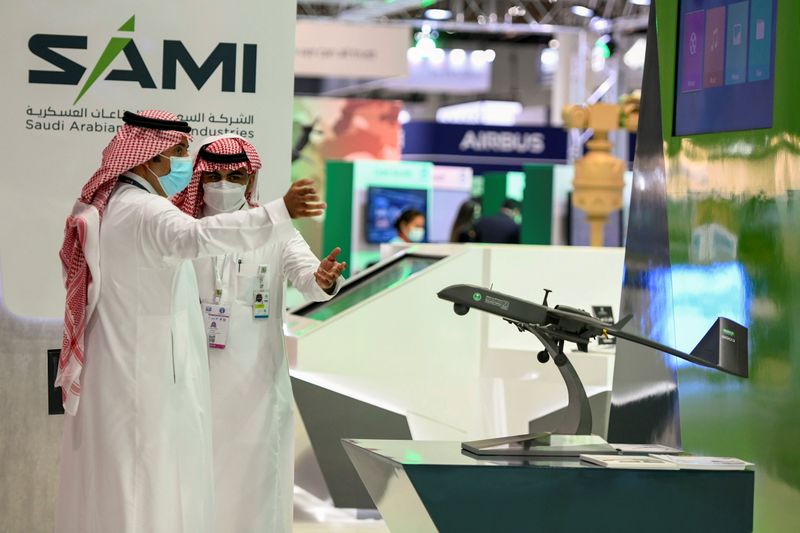 © Reuters. صورة من أرشيف رويترز لشخصين يقفان أمام شعار الشركة السعودية للصناعات العسكرية.