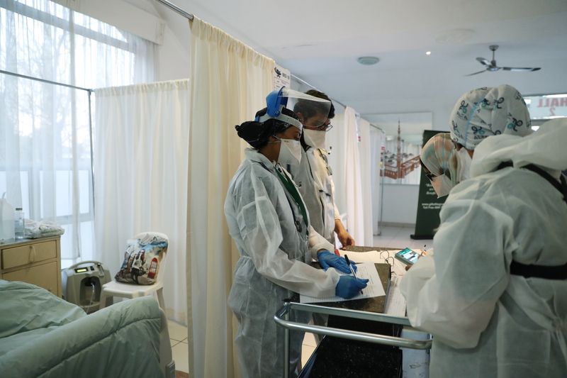 © Reuters. FILE PHOTO: Healthcare workers assist patients being treated at a makeshift hospital run by charity organisation The Gift of the Givers, during the coronavirus disease (COVID-19) outbreak in Johannesburg, South Africa, July 10, 2021. Picture taken July 10, 2021. REUTERS/ Sumaya Hisham