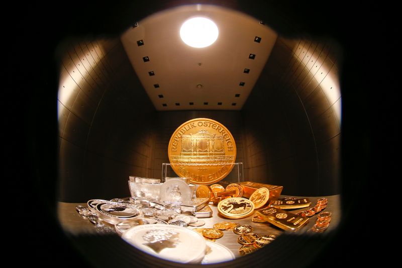 &copy; Reuters. Gold and silver bars and coins are stacked on a table in the safe deposit boxes room of the ProAurum gold house in Munich March 3, 2014. The rising threat of war between Ukraine and Russia sent investors scurrying for relative safety on Monday, pushing st