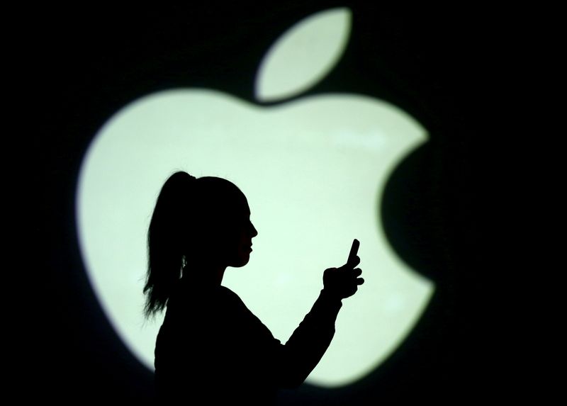 &copy; Reuters. FILE PHOTO: Silhouette of a mobile user seen next to a screen projection of the Apple logo in this picture illustration taken March 28, 2018.  REUTERS/Dado Ruvic/Illustration/File Photo