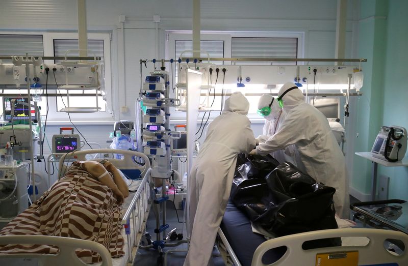 &copy; Reuters. Медики пакуют тело пациента, умершего на аппарате ИВЛ в ковидном отделении больницы в Калаче-на-Дону Волгоградской области. Россия, 14 ноябр