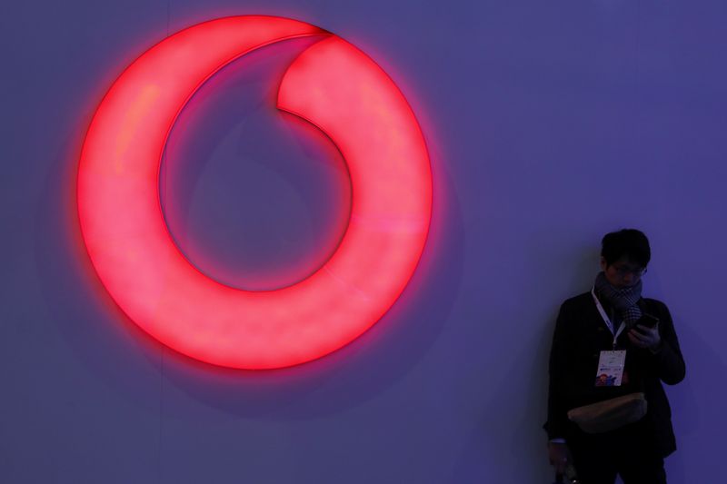 &copy; Reuters. FILE PHOTO: A man checks his mobile phone next to a Vodafone logo at the Mobile World Congress in Barcelona, Spain, February 28, 2018. REUTERS/Sergio Perez