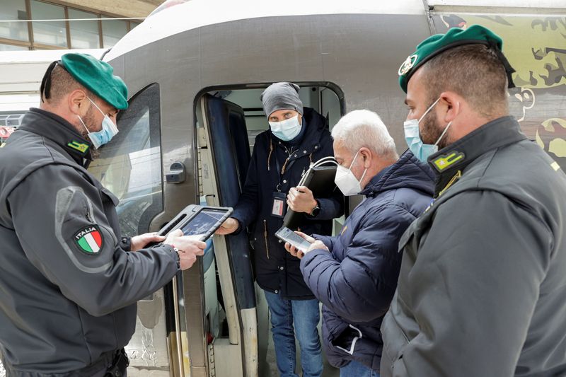 &copy; Reuters. Agentes de la Guardia di Finanza comprueban el pase sanitario de un viajero de tren en Nápoles, Italia. 6 diciembre 2021. REUTERS/Ciro de Luca