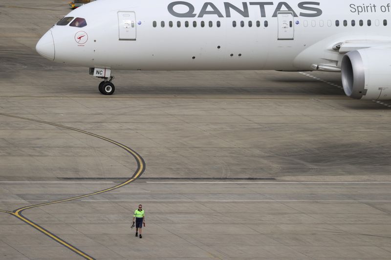 &copy; Reuters. FILE PHOTO: A ground worker walking near a Qantas plane is seen from the international terminal at Sydney Airport, as countries react to the new coronavirus Omicron variant amid the coronavirus disease (COVID-19) pandemic, in Sydney, Australia, November 2