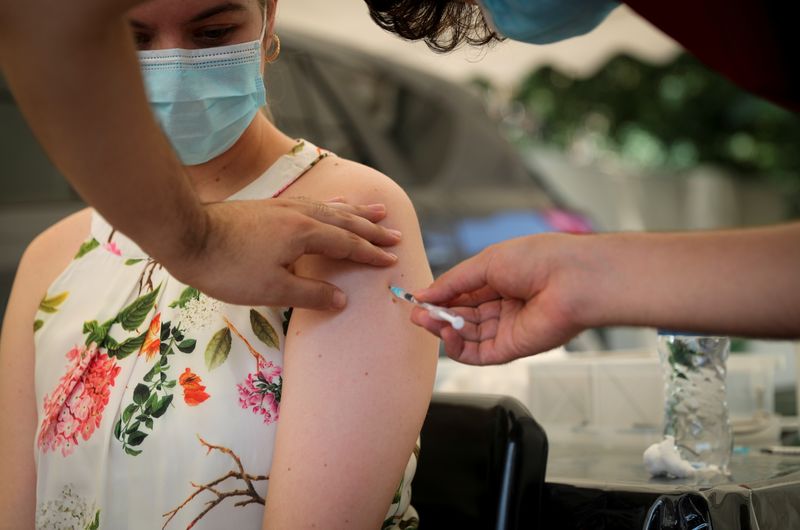 © Reuters. FILE PHOTO: A healthcare worker administers the coronavirus disease (COVID-19) vaccine to a woman, amidst the spread of the SARS-CoV-2 variant Omicron in Johannesburg, South Africa, December 04, 2021. Picture taken December 04, 2021. REUTERS/ Sumaya Hisham