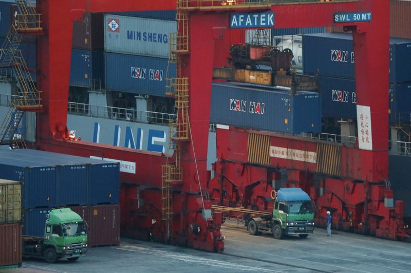 © Reuters. FILE PHOTO: Trucks wait to be loaded on with containers at a port in Keelung, Taiwan, June 10, 2020. REUTERS/Ann Wang/File Photo