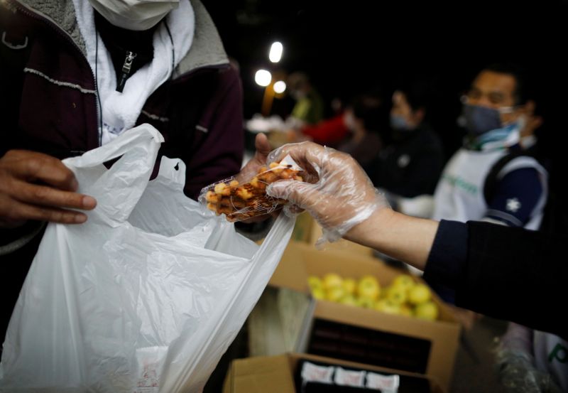 &copy; Reuters. FILE PHOTO: An elderly man receives food aid handouts for the needy, as the spread of the coronavirus disease (COVID-19) continues in Tokyo, Japan, May 9, 2020.  REUTERS/Issei Kato