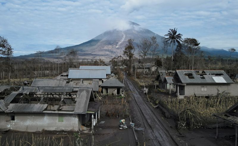 &copy; Reuters. Pessoa recolhe bens de casa danificada por erupção de vulcão em Lumajang, na Indonésia
07/12/2021 REUTERS/Willy Kurniawan 