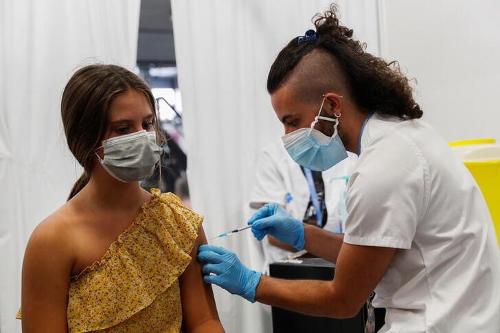 © Reuters. Menina de 12 anos recebe dose da vacina contra a Covid-19 da Pfizer em Barcelona, na Espanha
04/08/2021 REUTERS/ Albert Gea