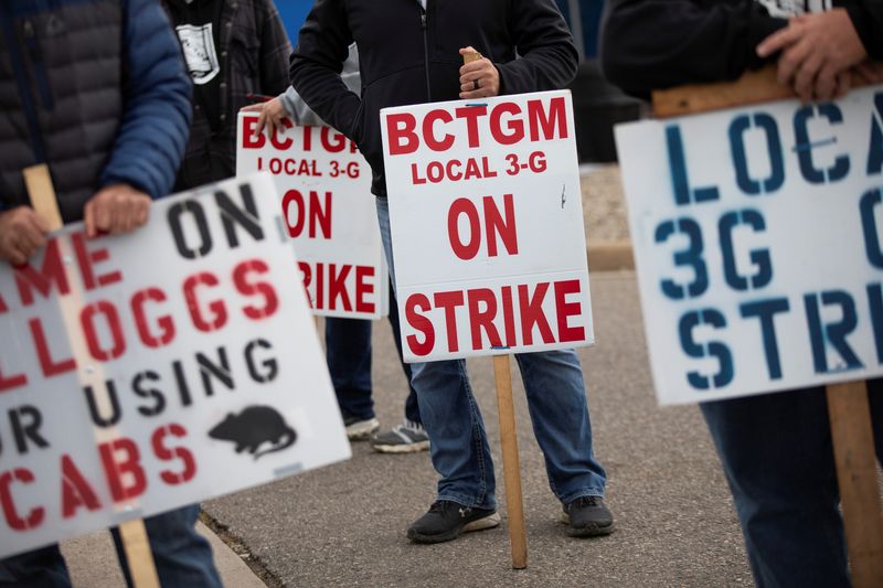 &copy; Reuters. FILE PHOTO: Union workers from Kellogg's gather with signs while they picket outside the cereal maker's headquarters as they remain on strike in Battle Creek, Michigan, U.S., October 21, 2021.  REUTERS/Emily Elconin