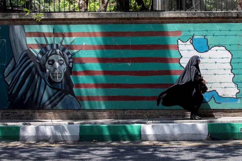 &copy; Reuters. FILE PHOTO: A woman walks past the mural showing U.S. flag with barbed wire and the Statue Of Liberty with skull face in Tehran, Iran June 25, 2019.  Nazanin Tabatabaee/Nazanin Tabatabaee/West Asia News Agency via REUTERS/File Photo