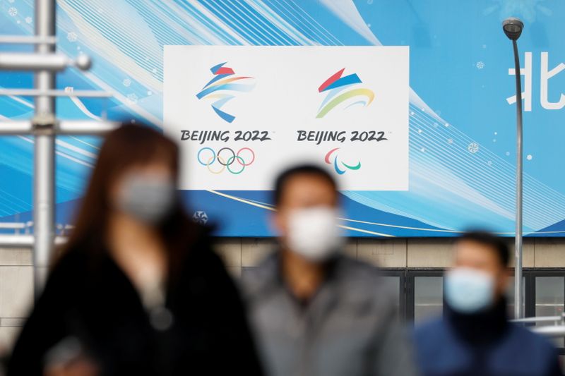 &copy; Reuters. Pedestrians walk past the emblems of Beijing 2022 Winter Olympic and Paralympic Games near a flagship merchandise store for the Beijing 2022 Winter Olympics in Beijing, China December 8, 2021. REUTERS/Carlos Garcia Rawlins
