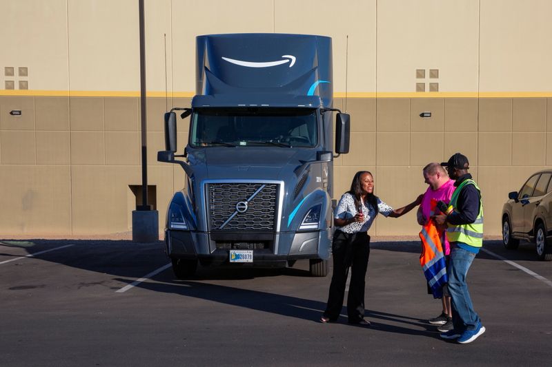 &copy; Reuters. Amazon Freight Partner Ebony McKinley talks with truck drivers Ian Crocker and Ray Land during a shift change at Seven Strong Trucking in Phoenix, Arizona, U.S., December 2, 2021. REUTERS/Caitlin O'Hara