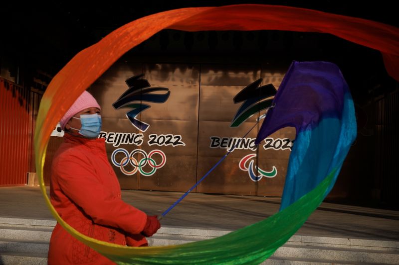 &copy; Reuters. امرأة تستعرض شريطا ملونا بجوار شعار أولمبياد طوكيو الشتوية في بكين يوم 8 ديسمبر كانون الأول 2021. رويترز