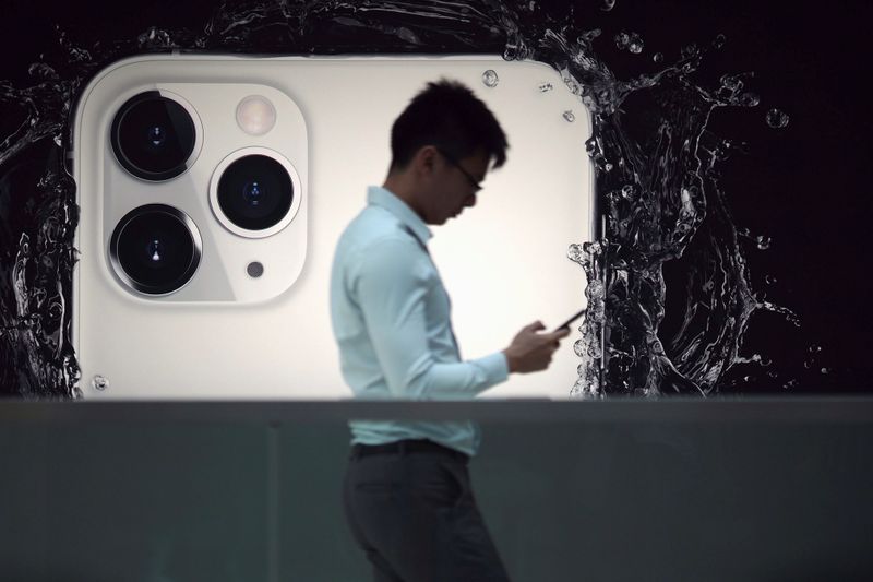 &copy; Reuters. Un hombre camina junto a un anuncio del nuevo iPhone 11 Pro de Apple en la tienda de Apple en IFC, distrito central, Hong Kong, China. 10 de octubre de 2019. REUTERS/Athit Perawongmetha