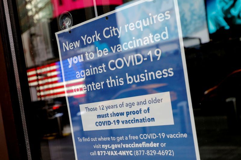 &copy; Reuters. FILE PHOTO: A sign is pictured on the door of a restaurant requiring patrons to be vaccinated against COVID-19 in Times Square in Manhattan New York City, New York, U.S., December 7, 2021. REUTERS/Mike Segar/File Photo