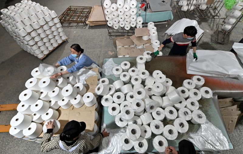 &copy; Reuters. FILE PHOTO: Workers are seen on the production line at a cotton textile factory in Korla, Xinjiang Uighur Autonomous Region, China April 1, 2021. Picture taken April 1, 2021. cnsphoto via REUTERS /File Photo