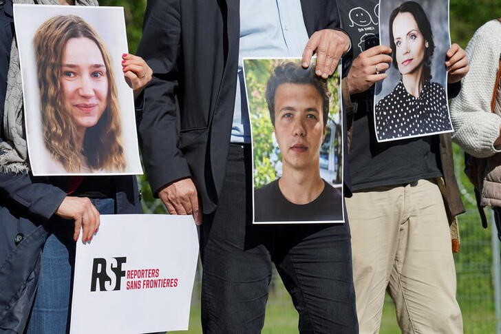 © Reuters. FILE PHOTO: Press advocacy group Reporters Sans Frontiers activists hold photos of journalists detained in Belarus at Salcininkai border crossing point, Lithuania on May 27, 2021. REUTERS/Janis Laizans
