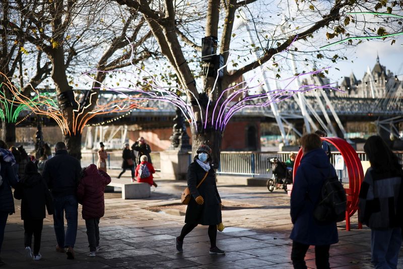 &copy; Reuters. FILE PHOTO: A person wearing a protective face mask walks past seasonal illuminations on the South Bank, amid the coronavirus disease (COVID-19) outbreak in London, Britain, December 4, 2021. REUTERS/Henry Nicholls