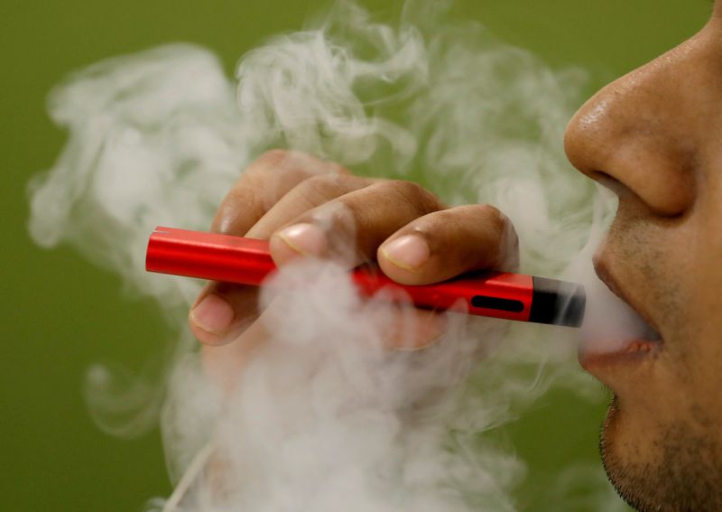 © Reuters. FILE PHOTO: A man uses a vape device in this illustration picture, September 19, 2019. REUTERS/Adnan Abidi/Illustration