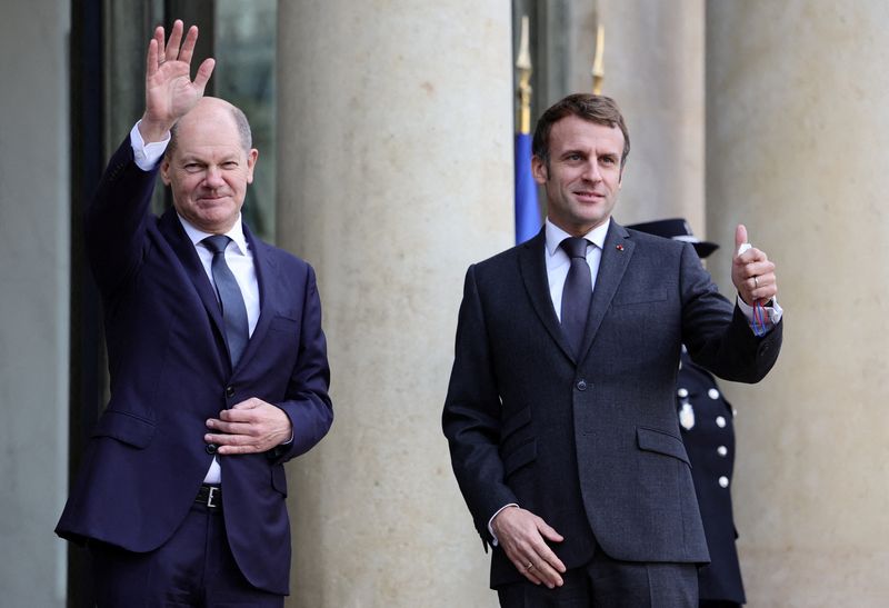 © Reuters. French President Emmanuel Macron and German Chancellor Olaf Scholz wave to journalists before a meeting at the Elysee Palace in Paris, France, December 10, 2021. REUTERS/Sarah Meyssonnier