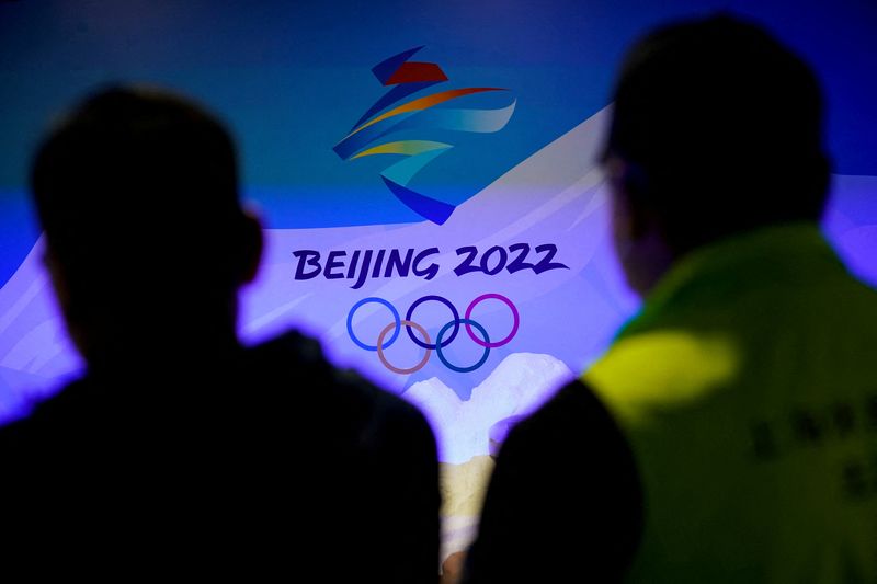 &copy; Reuters. FILE PHOTO: Staff members work near the emblem for Beijing 2022 Winter Olympics displayed at the Shanghai Sports Museum in Shanghai, China, December 8, 2021. REUTERS/Aly Song/File Photo