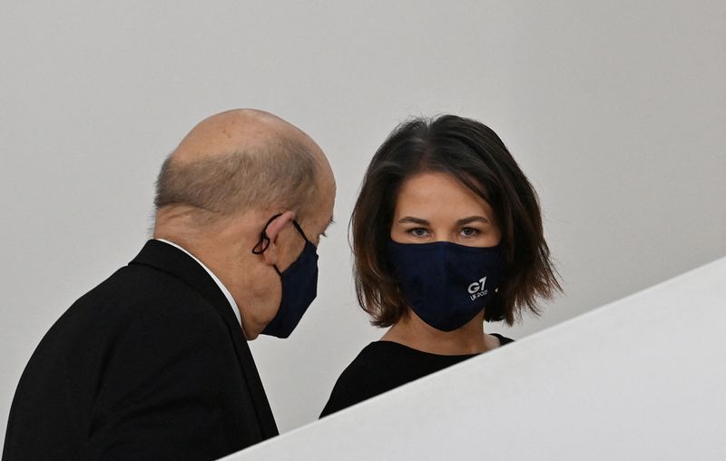 © Reuters. French Foreign Minister Jean-Yves Le Drian and German Foreign Minister Annalena Baerbock arrive for a family photo at the Museum of Liverpool during the G7 summit of foreign and development ministers in Liverpool, Britain December 11, 2021. Paul Ellis/Pool via REUTERS