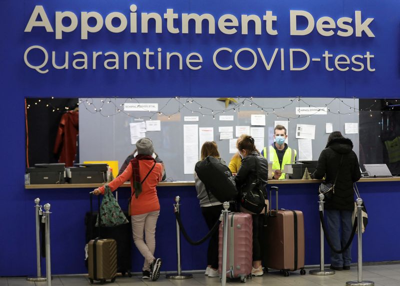 &copy; Reuters. People wait in front of an "Appointment Desk" for quarantine and coronavirus disease (COVID-19) test appointments inside Schiphol Airport, after Dutch health authorities said that 61 people who arrived in Amsterdam on flights from South Africa tested posi