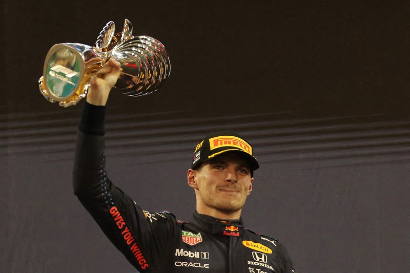 &copy; Reuters. Max Verstappen de Red Bull celebra la victoria de la carrera y el campeonato mundial en el podio con el trofeo. Formula Uno - Gran Premio de Abu Dhabi - Circuito Yas Marina, Abu Dhabi, Emiratos Árabes Unidos - 12 de diciembre de 2021  Pool a través de R