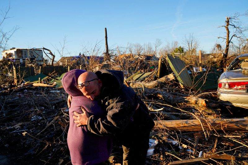 © Reuters. Timothy McDill, 48, hugs his neighbor Marge Conner, 77, after a devastating outbreak of tornadoes ripped through several U.S. states in Mayfield, Kentucky, U.S. December 12, 2021. Neither had seen each other since before the night of the storm and had been concerned about the others safety and survival. REUTERS/Cheney Orr    