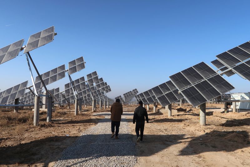 © Reuters. Imagen de archivo de trabajadores caminando en una estación de energía solar en Tongchuan, provincia de Shaanxi, China. 11 de diciembre, 2019. REUTERS/Muyu Xu/Archivo