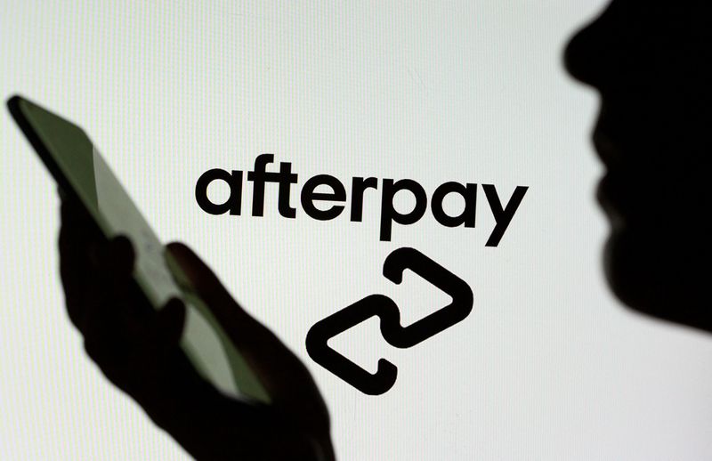 &copy; Reuters. FILE PHOTO: Woman with a smartphone is seen in front of a displayed Afterpay logo in this illustration taken, August 2, 2021. REUTERS/Dado Ruvic/Illustration