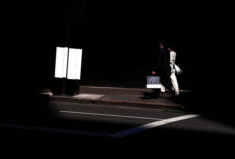 &copy; Reuters. FILE PHOTO: A shopper carries a bag displaying the word 'Sale' as he walks along a footpath outside a retail store in central Sydney, Australia, September 11, 2018.    REUTERS/David Gray