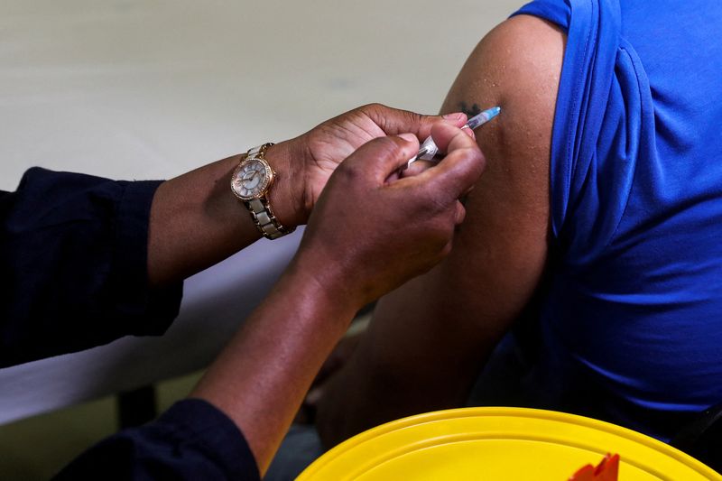 © Reuters. FILE PHOTO: A healthcare worker administers the Pfizer coronavirus disease (COVID-19) vaccine to a man, amidst the spread of the SARS-CoV-2 variant Omicron, in Johannesburg, South Africa, December 9, 2021. REUTERS/Sumaya Hisham/File Photo