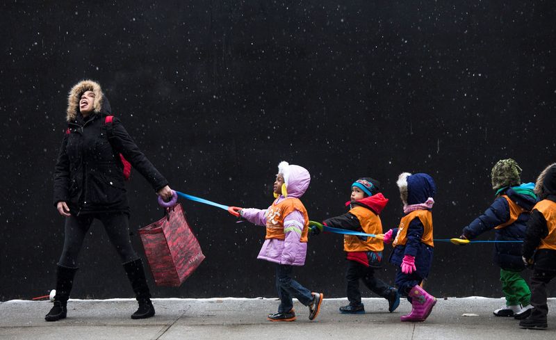 &copy; Reuters. FILE PHOTO: A schoolteacher, who wished to stay unidentified, attempts to catch snowflakes while leading her students to a library from school in the Harlem neighborhood, located in the Manhattan borough of New York on January 10, 2014.  REUTERS/Adrees La