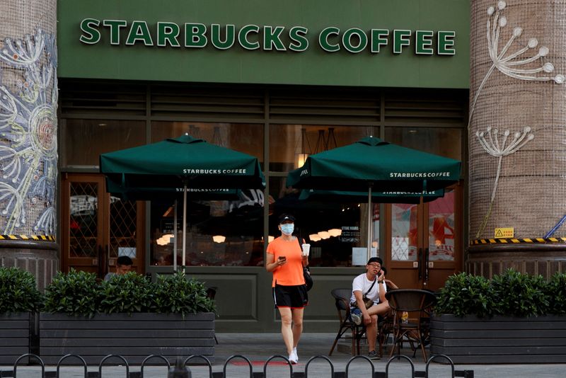 &copy; Reuters. FILE PHOTO: A woman leaves a cafe of Starbucks Coffee in Beijing, China, July 6, 2020. REUTERS/Thomas Peter/File Photo