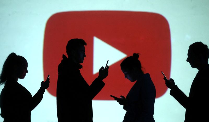 &copy; Reuters. Silhouettes of mobile users are seen next to a screen projection of Youtube logo in this picture illustration taken March 28, 2018.  REUTERS/Dado Ruvic/Illustration/file photo