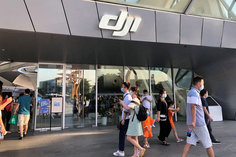 &copy; Reuters. FILE PHOTO: People wearing face masks following the coronavirus disease (COVID-19) outbreak walk past DJI's flagship store in Shenzhen, Guangdong province, China August 8, 2020. Picture taken August 8, 2020. REUTERS/David Kirton