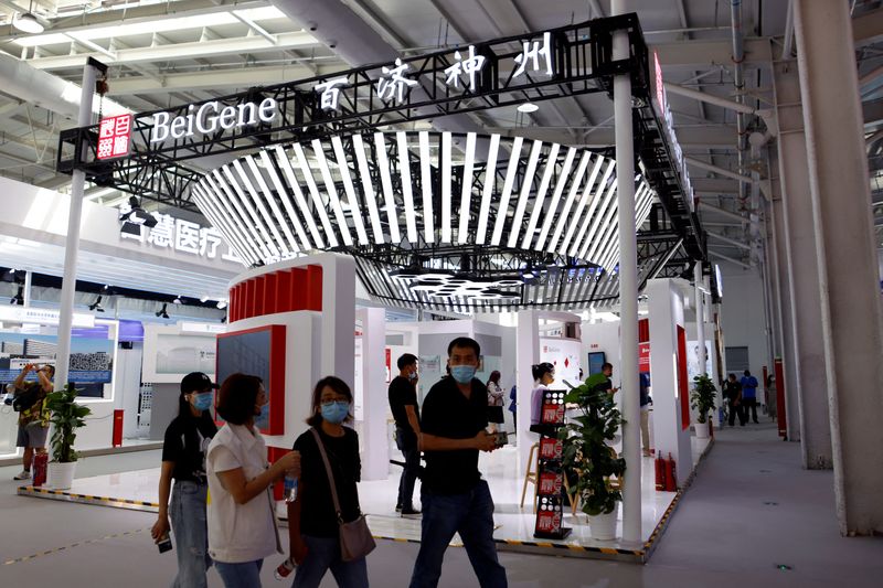 © Reuters. FILE PHOTO: People walk past a booth of biotech company Beigene at the 2021 China International Fair for Trade in Services (CIFTIS) in Beijing, China September 3, 2021. REUTERS/Florence Lo/File Photo