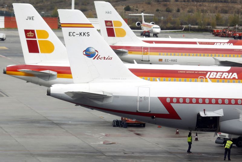 &copy; Reuters. FILE PHOTO: Staff stand under an Iberia airplane parked on the tarmac at Madrid's Barajas airport November 9, 2012.  REUTERS/Sergio Perez