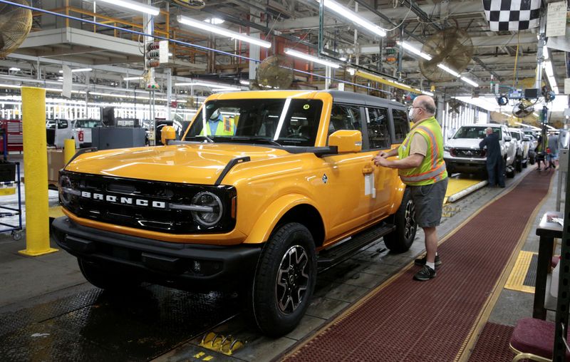 &copy; Reuters. FILE PHOTO: A Ford Motor assembly worker adds a sticker to a finished Ford 2021 Bronco SUV on the assembly line at Michigan Assembly Plant in Wayne, Michigan, U.S., June 14, 2021.  REUTERS/Rebecca Cook/File Photo