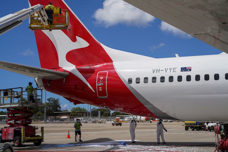 &copy; Reuters. FILE PHOTO: Aircraft appearance crew members clean an aircraft as Qantas begins preparing and equipping planes for the return of international flights, in anticipation of Australia easing coronavirus disease (COVID-19) border regulations, at Sydney Airpor