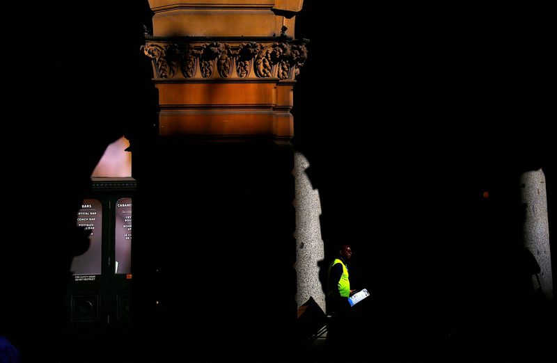 &copy; Reuters. FILE PHOTO: A worker walks through the archway of a historical building as he delivers parcels in central Sydney, Australia July 25, 2017. REUTERS/David Gray