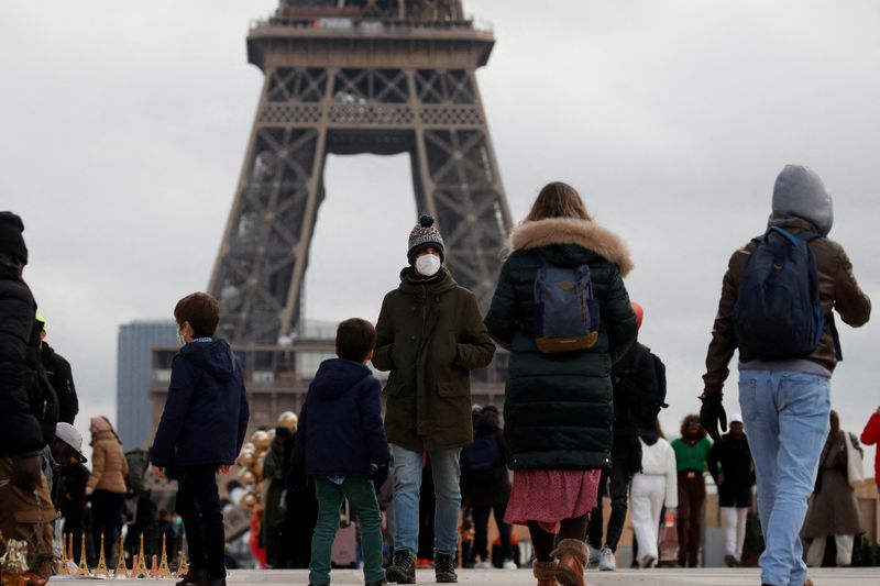 &copy; Reuters. FILE PHOTO: People, wearing protective face masks, walk on Trocadero square near the Eiffel Tower in Paris amid the coronavirus disease (COVID-19) outbreak in France, December 6, 2021. REUTERS/Gonzalo Fuentes/File Photo