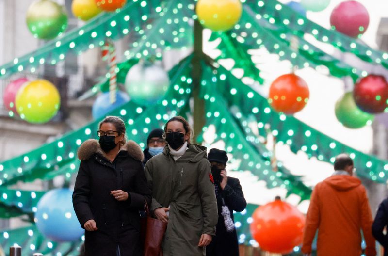 &copy; Reuters. People wearing face masks walk in front of a Christmas tree carousel amid the coronavirus disease (COVID-19) outbreak, in Nantes, in France, December 7, 2021. REUTERS/Stephane Mahe