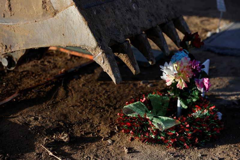 &copy; Reuters. Delaney Washburn, 18, uses a backhoe excavator for digging graves next to a funeral site at the Kirtland Fruitland Cemetery in Kirtland, New Mexico, U.S., December 15, 2021.  REUTERS/Shannon Stapleton/File Photo