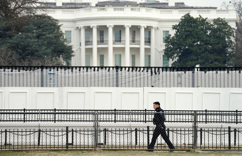&copy; Reuters. FILE PHOTO: A member of the Secret Service walks along security fence installed around the White House days after supporters of U.S. President Donald Trump stormed the Capitol in Washington, U.S., January 11, 2021.  REUTERS/Kevin Lamarque/File Photo
