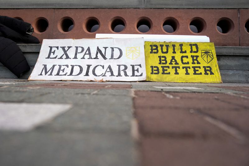 &copy; Reuters. Signs that read "Build Back Better" and "Expand Medicare" are seen as U.S. Senator Sherrod Brown (D-OH) speaks about the Build Back Better package outside the U.S. Capitol in Washington, December 15, 2021. REUTERS/Elizabeth Frantz